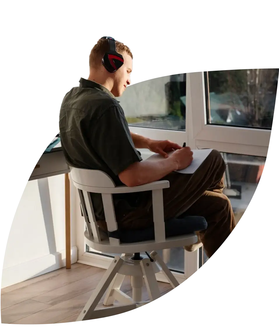 man drawing while wearing headphones