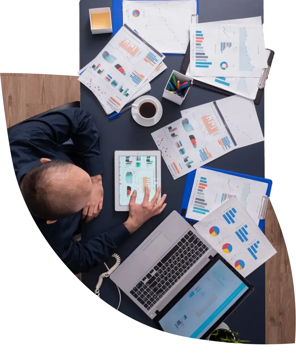 a man on a desk filled with charts