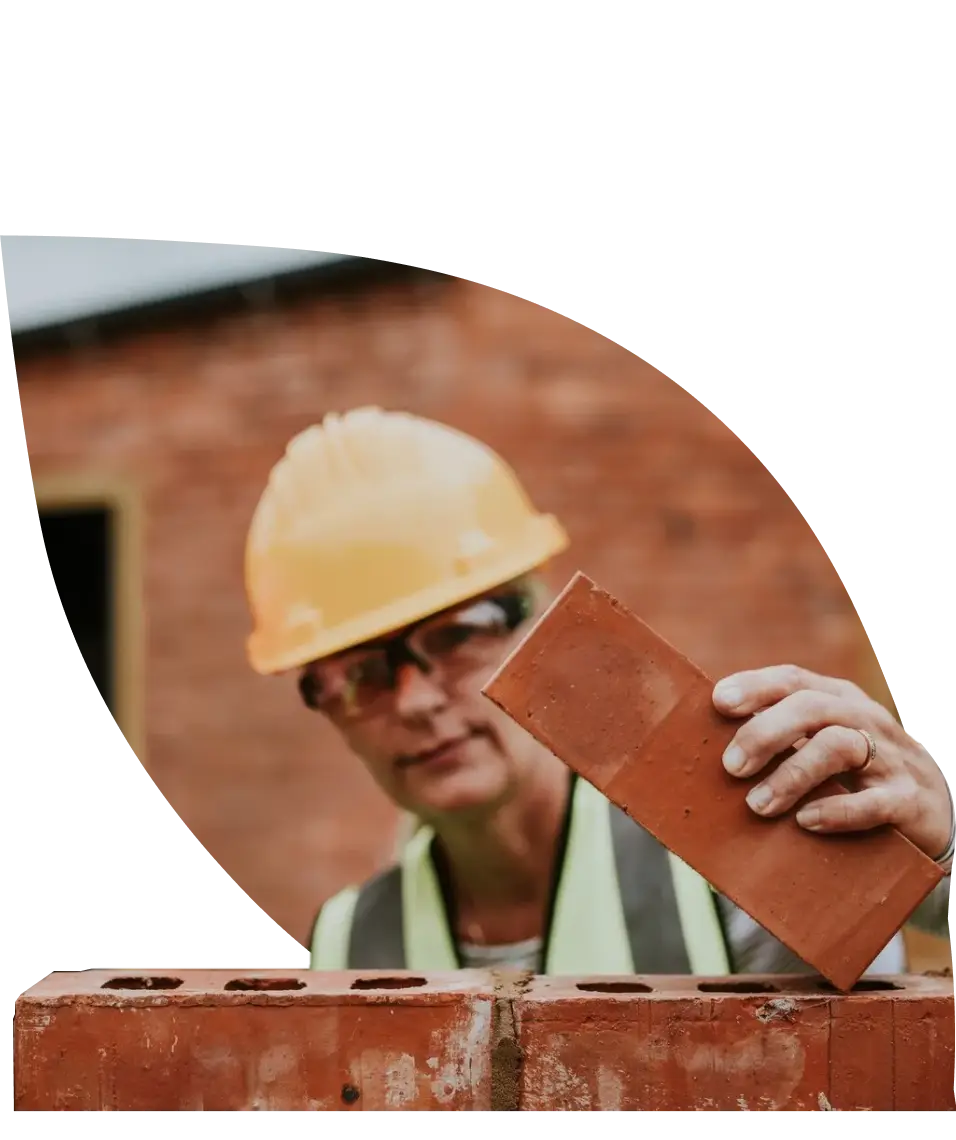 worker placing a brick while building a brick wall